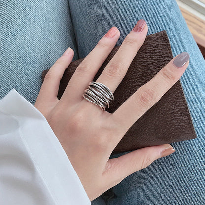 Silberner Stapelring an Hand, braune Geldbörse, blaue Jeans, modisches Accessoire.