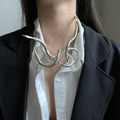 Silberne Schlangen-Halskette, modisch, Damen, elegantes Design, auf weißer Bluse und schwarzem Blazer.