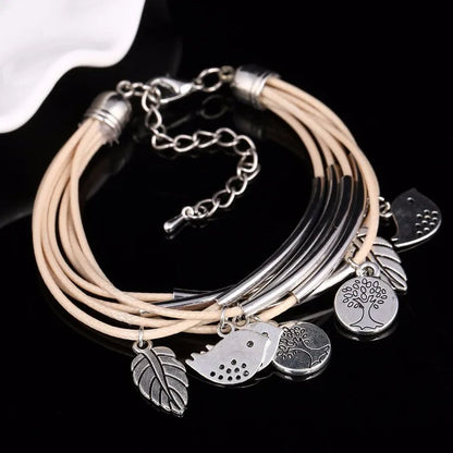 Mehrlagiges Armband mit silbernen Anhängern, Lederbänder, Baum- und Blattdesign, Damenmode.