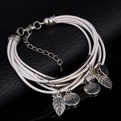 Silber-Armband mit weißen Lederbändern und Blattanhängern, modisches Schmuckstück.