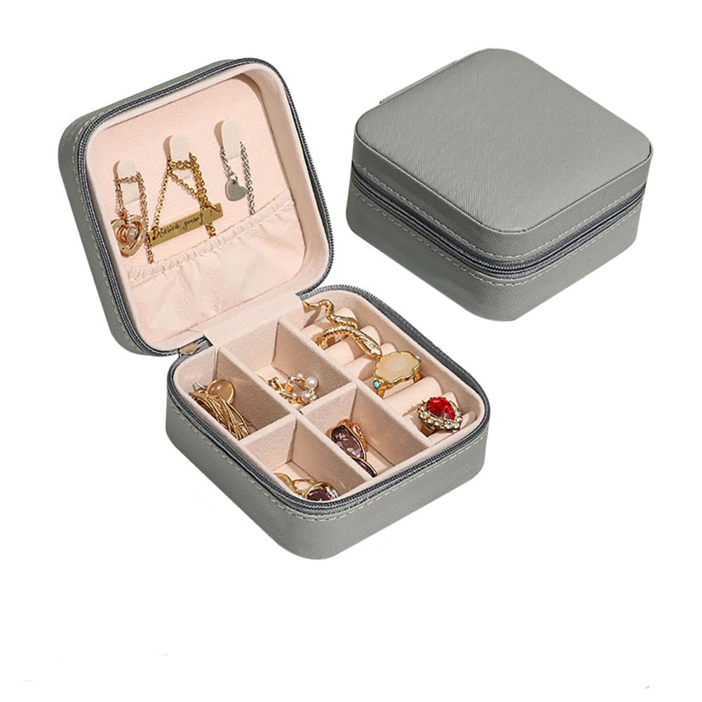 Graues Schmuckkästchen aus Leder mit Fächern, ideal zur Aufbewahrung von Ohrringen und Ringen.