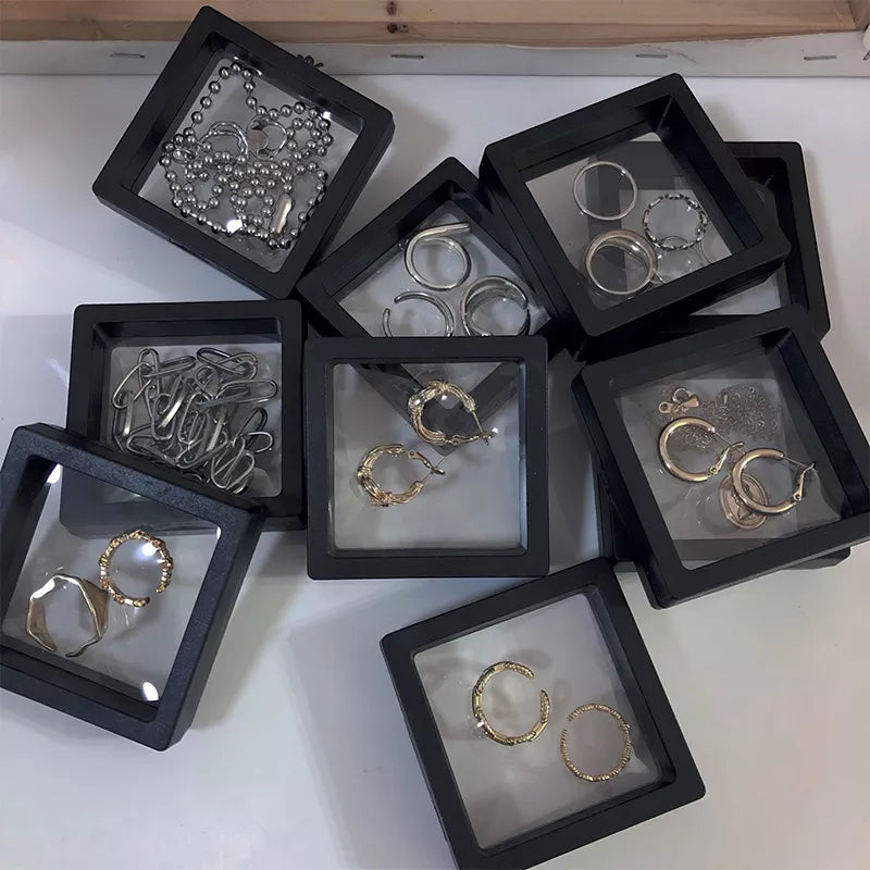 Silberne und goldene Ohrringe in schwarzen Schmuckboxen, modische Accessoires, stilvoller Schmuck.
