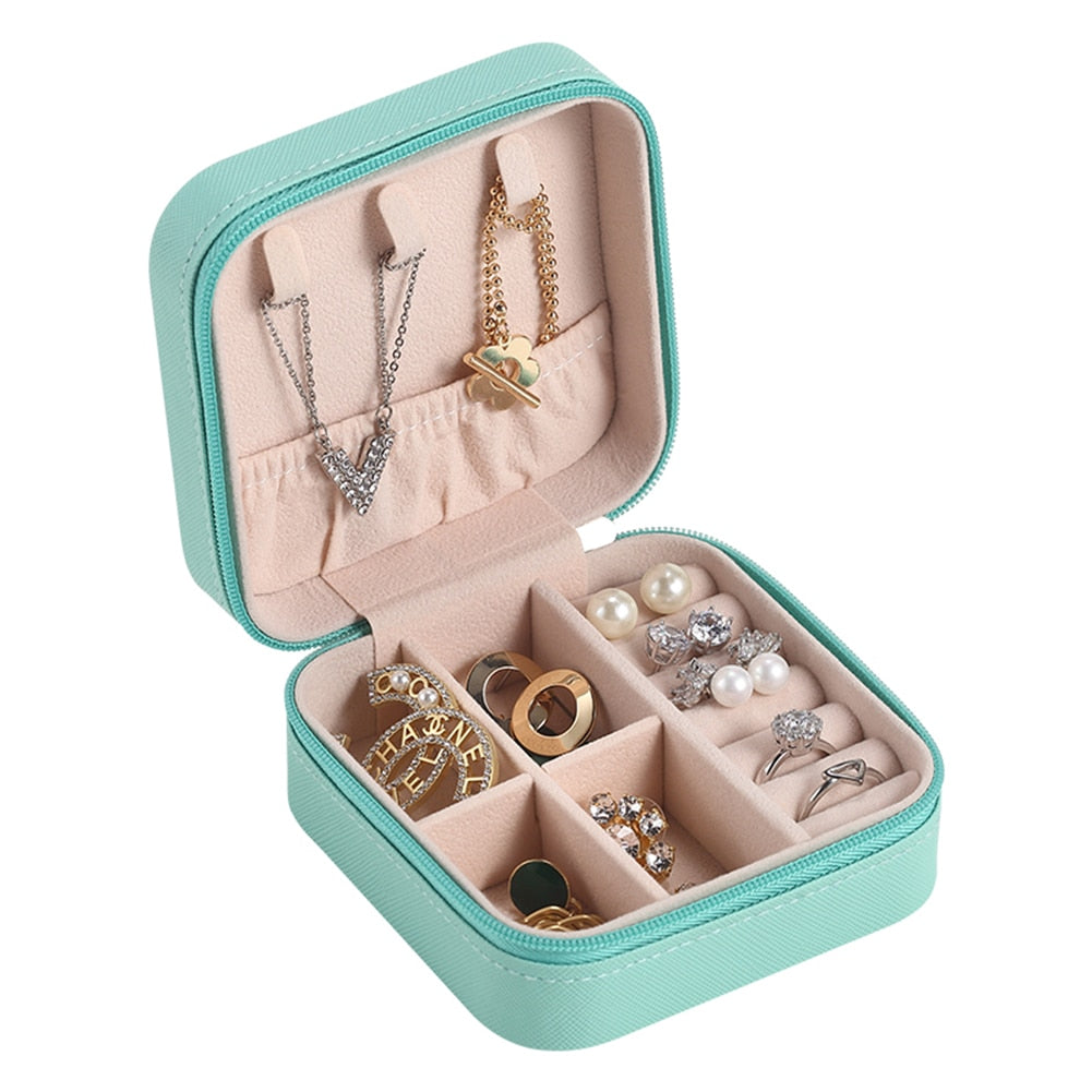 Türkisfarbene Schmuckbox mit Fächern, Ketten, Ringen und Ohrringen, ideal für Reisen.