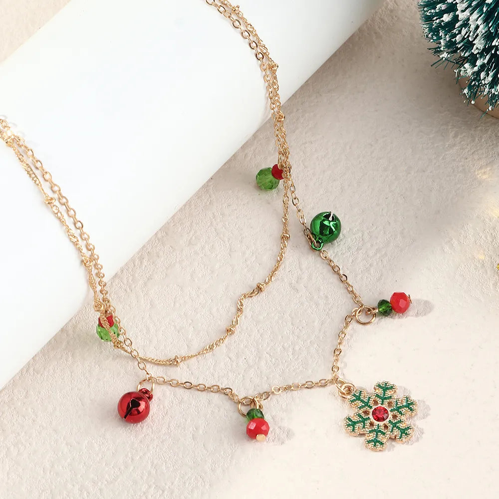 Goldene Halskette mit Weihnachtsanhänger, Schneeflocke, rot-grüne Perlen, festlicher Schmuck.