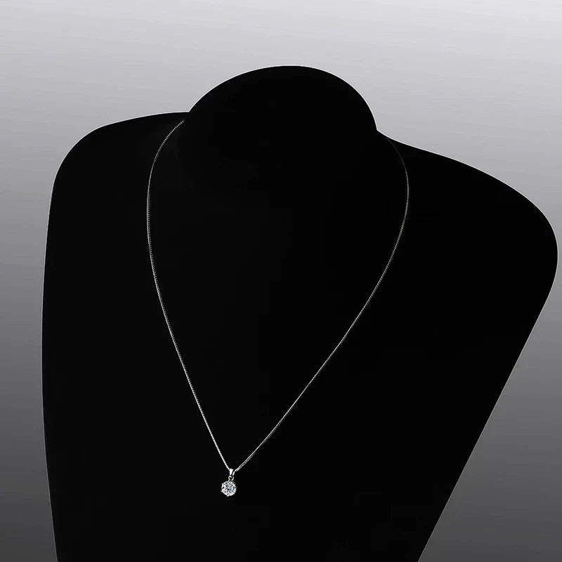Silberne Halskette mit rundem Diamantanhänger auf schwarzem Hintergrund, eleganter Schmuck.