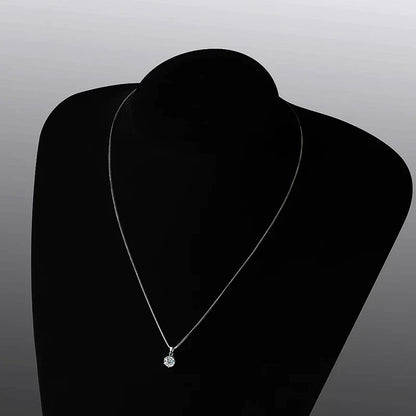 Silberne Halskette mit rundem Diamantanhänger auf schwarzem Hintergrund, eleganter Schmuck.