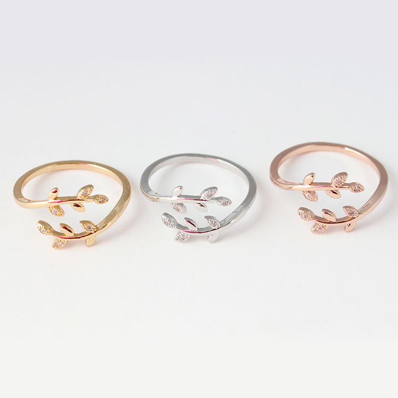 Drei filigrane Ringe in Gold, Silber und Roségold mit Blattdesign und Zirkonia-Steinen.