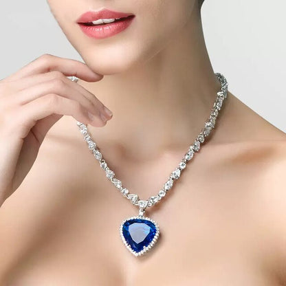 Frau mit Diamantkette und blauem Herzanhänger, eleganter Schmuck, luxuriöses Accessoire.