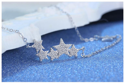 Silberne Stern-Halskette mit Strasssteinen auf blauem Hintergrund, eleganter Schmuck.
