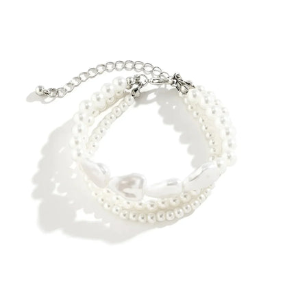 Dreireihiges Armband aus weißen Perlen mit verstellbarem Verschluss, eleganter Schmuck.