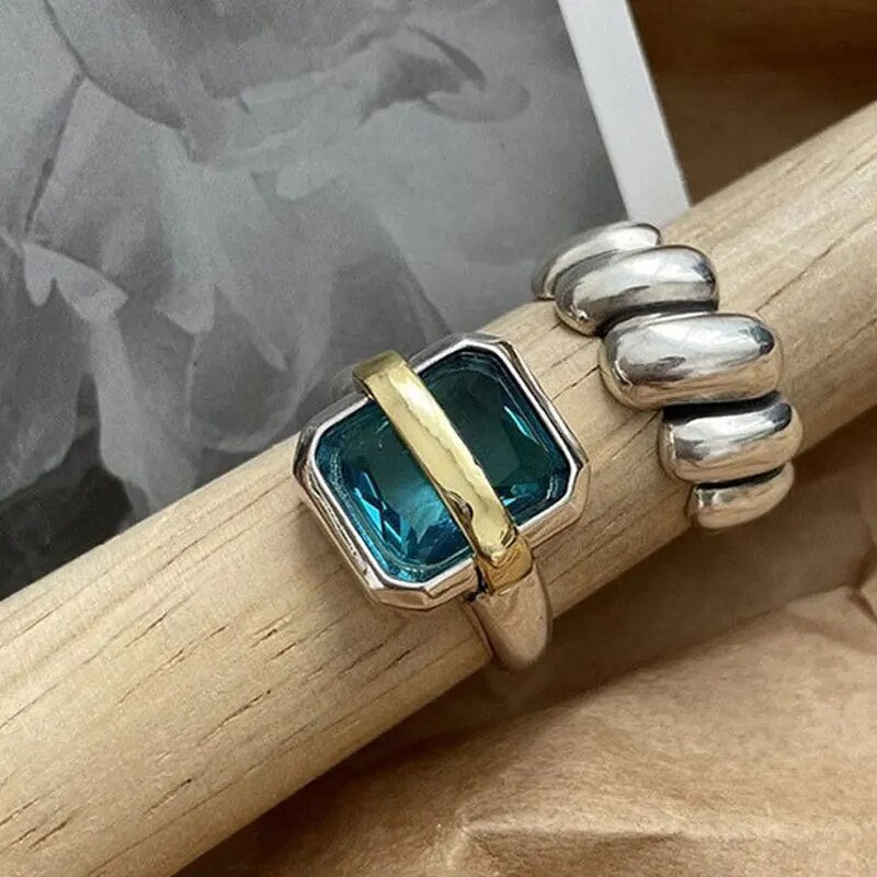 Silberring mit blauem Edelstein und goldener Verzierung, moderner Schmuck, stilvoll, elegant.