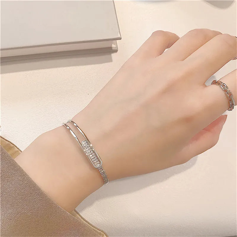 Silbernes Armband mit Strasssteinen auf Handgelenk, elegantes Schmuckdesign, Damenaccessoire.
