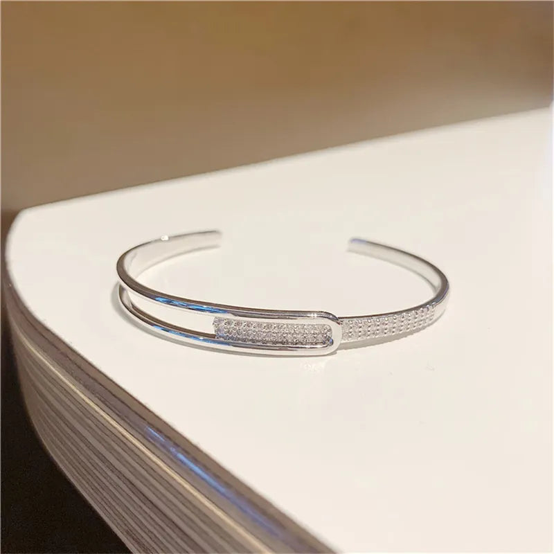 Silbernes Armreif-Armband mit Strasssteinen, elegantes Design, Schmuck für Damen.