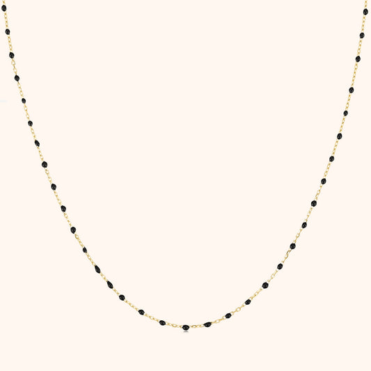 Goldene Halskette mit schwarzen Perlen, elegantes Schmuckdesign, Damenaccessoire.
