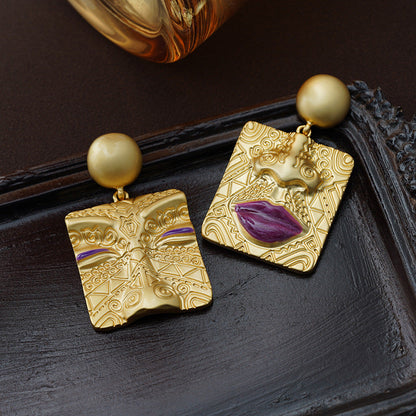 Asymmetrische goldene Ohrringe mit Gesichtsmotiv, Retro-Design, Messing, lila Akzent.