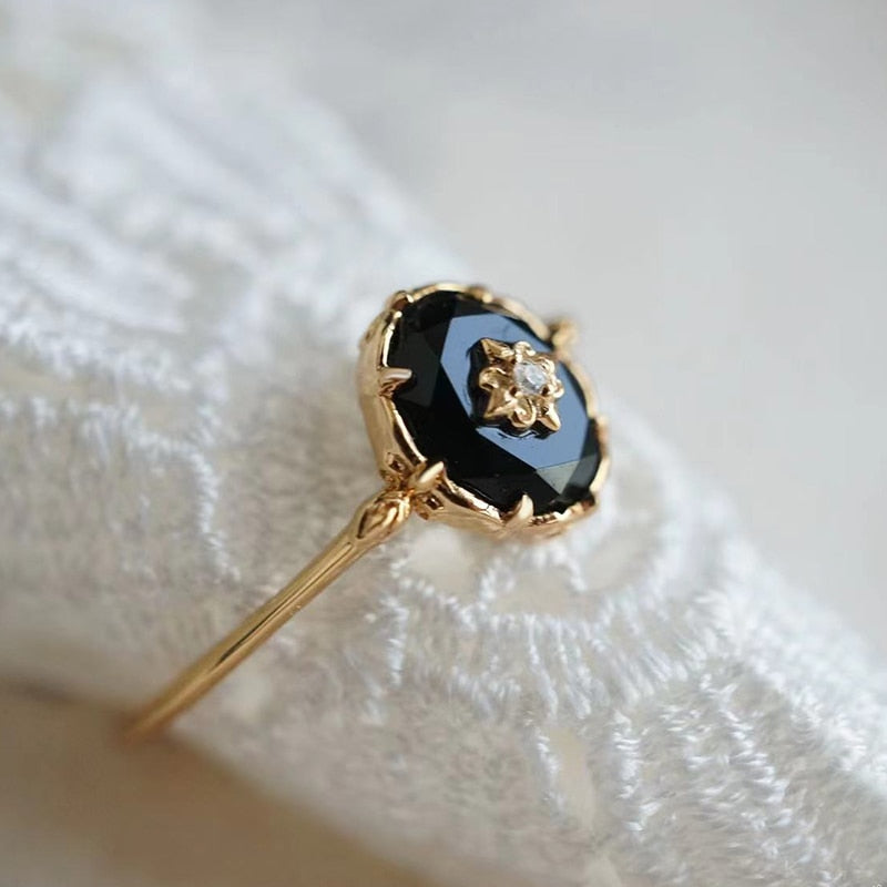 Goldener Ring mit schwarzem Onyx und Diamant, elegantes Schmuckdesign, luxuriöses Accessoire.