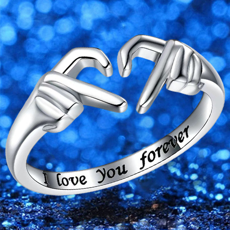 Silberring mit Handzeichen-Design, "I love you forever" Gravur, vor blauem Hintergrund.