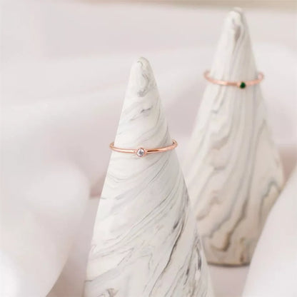 Roségoldener Ring mit Diamant auf Marmorkegel, minimalistischer Schmuck, elegantes Design.
