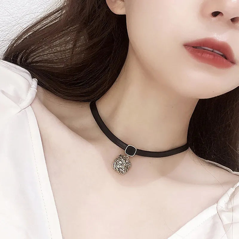 Schwarzes Lederhalsband mit silbernem Anhänger, modisches Accessoire für Damen.