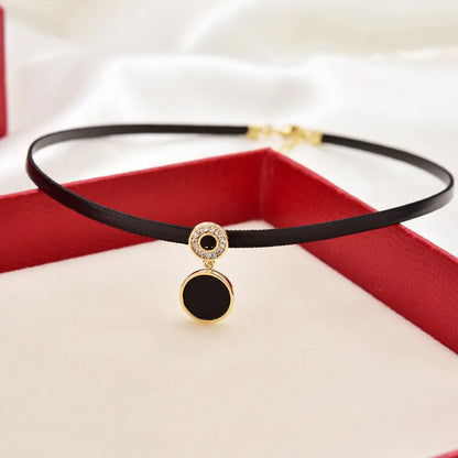 Schwarzes Samt-Choker-Halsband mit rundem Anhänger, goldfarben, eleganter Schmuck.