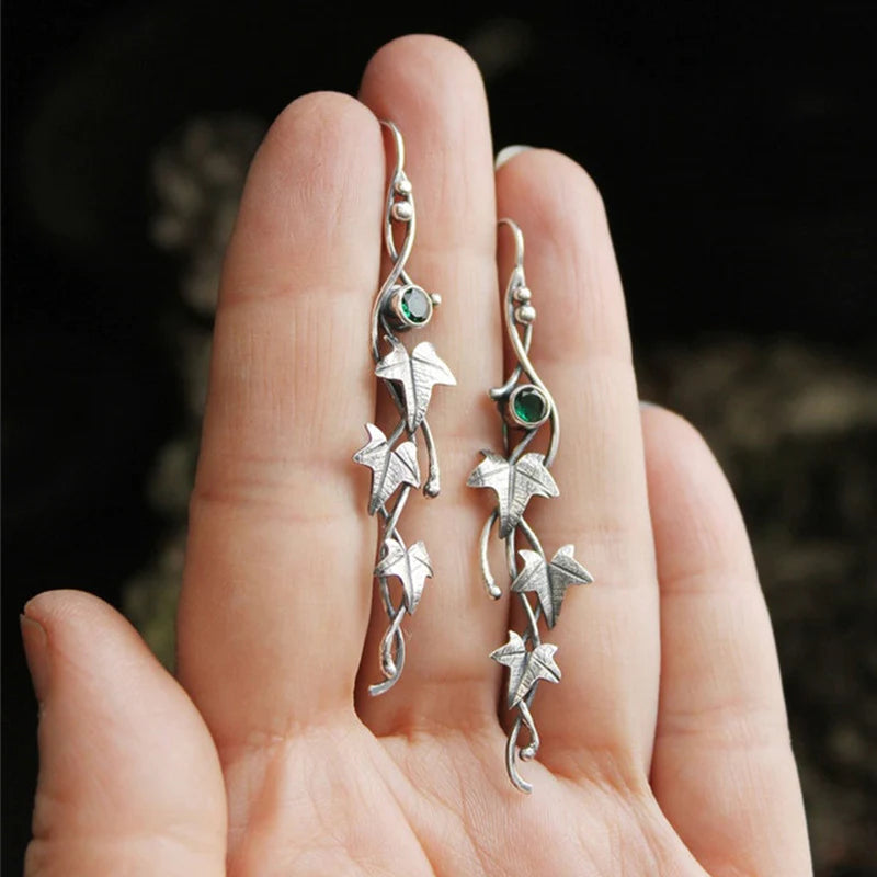 Silberne Ohrringe mit Blattdesign und grünen Steinen, handgefertigter Schmuck, elegant, einzigartig.