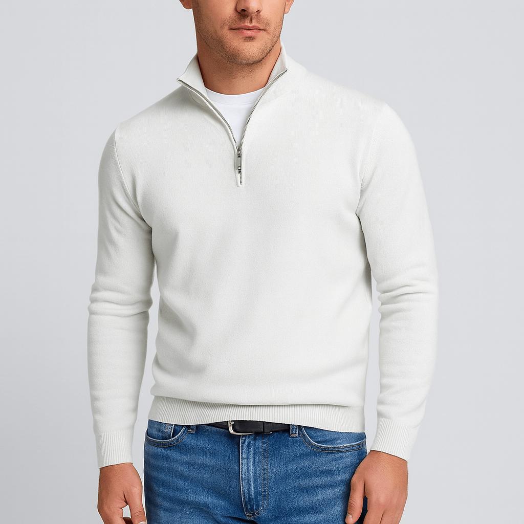 Model i hvid strikbluse med lynlås i halsen og hvid t-shirt under, sort bælte og blå jeans. 10