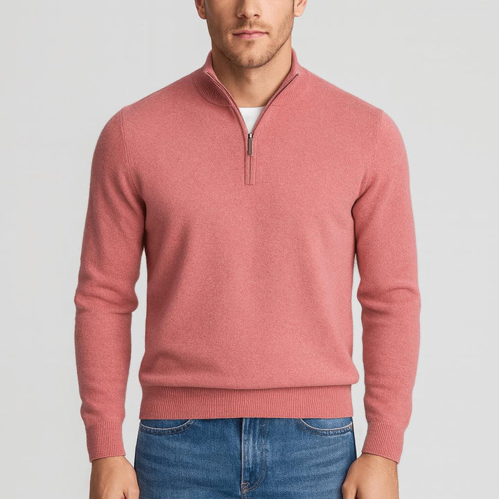 Model i rosa strikbluse med kort lynlås og høj krave, ribkanter ved ærmer og bund, blå jeans. 14