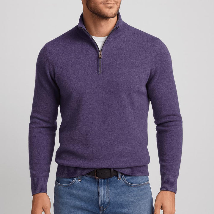 Model i lilla strikbluse med kort lynlås og høj krave, sort bælte og blå jeans, set forfra. 15