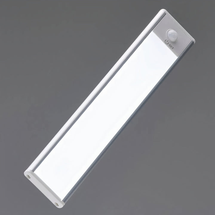 Lampen set skråt fra siden mod grå baggrund, med bevægelsessensor og tænd-knap i den ene ende. 7