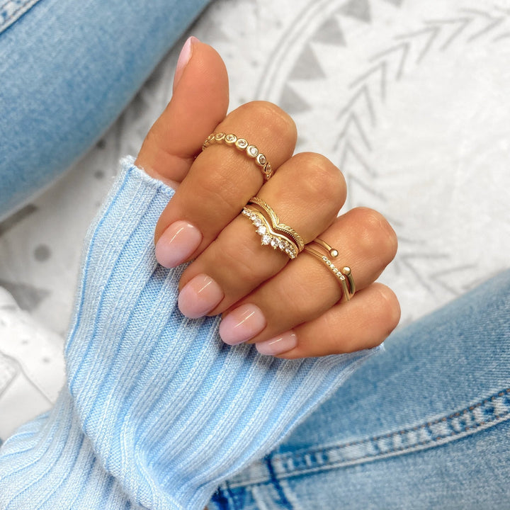 Damenhand mit goldenen Ringen, modisches Accessoire, elegantes Design, Nahaufnahme.