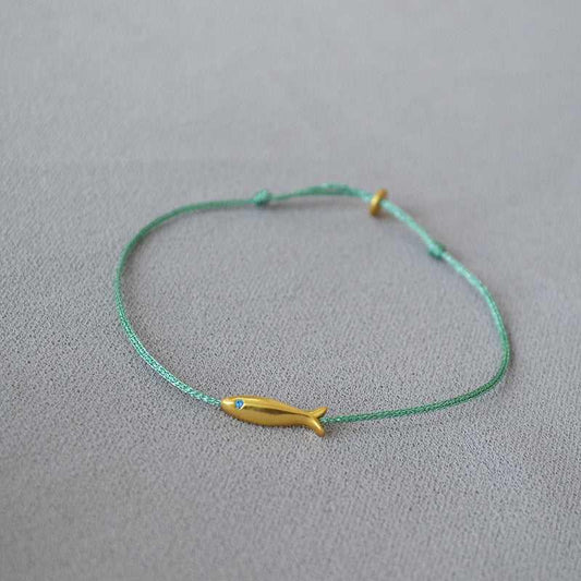 Grünes Armband mit gelbem Fischanhänger, minimalistisches Schmuckdesign, handgefertigt.