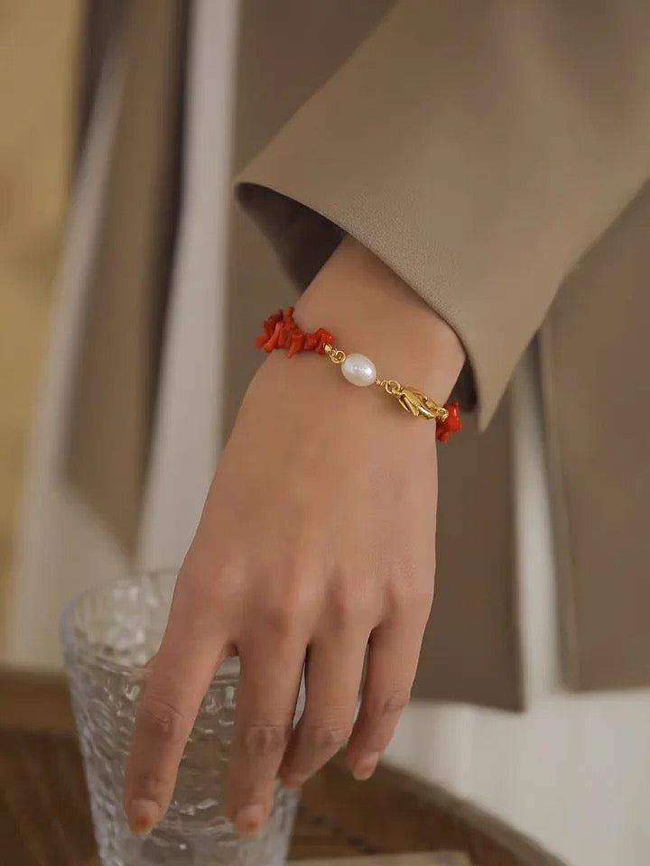 Damenarmband mit rotem Korallen- und Perlenanhänger, eleganter Schmuck, goldener Verschluss.