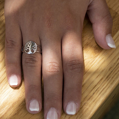 Silberring mit Lebensbaum-Motiv auf Hand, Holzoberfläche, Schmuck, Damenring, Geschenkidee.