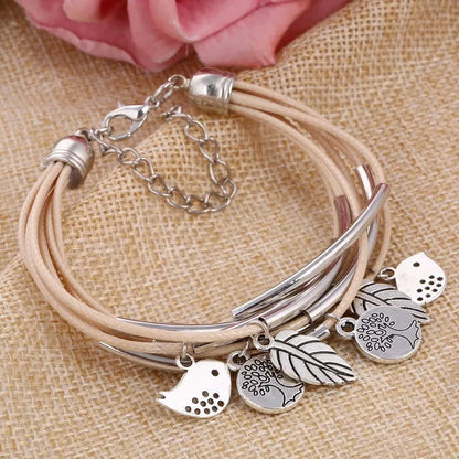 Beiges Lederarmband mit silbernen Anhängern, Blumen- und Vogelmotiven, Damenmode-Schmuck.