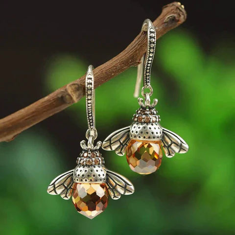 Bienen-Ohrringe aus Silber mit bernsteinfarbenen Kristallen, hängend an Ast, Schmuckdesign.