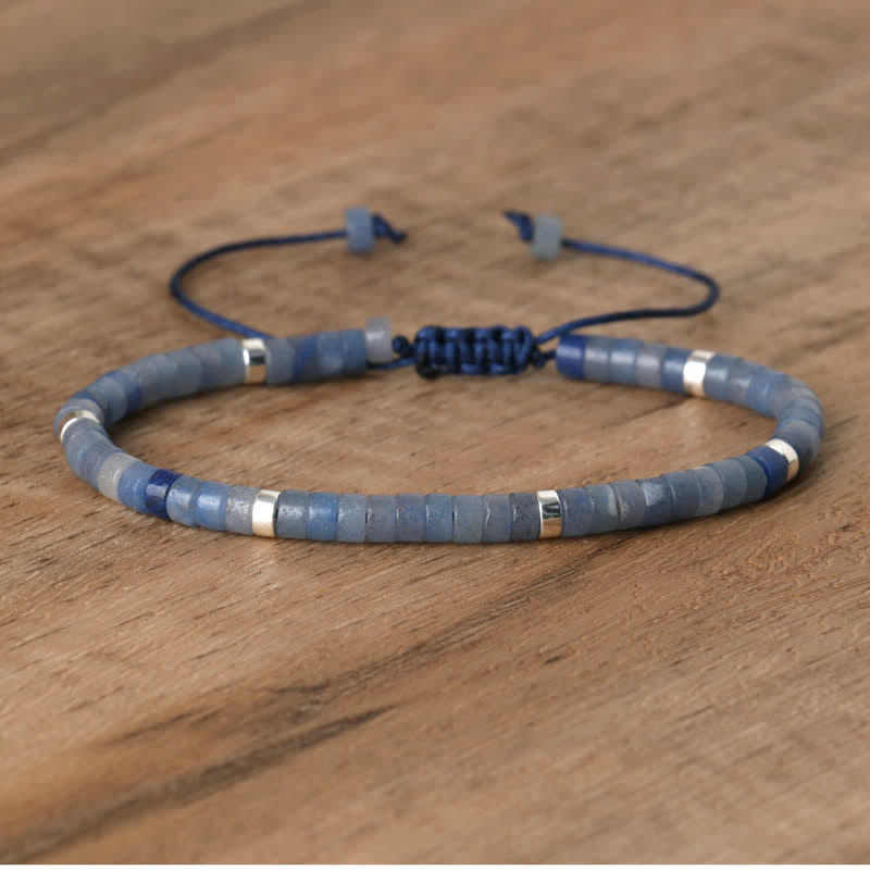 Blaues Armband aus Steinperlen mit silbernen Akzenten auf Holzoberfläche.