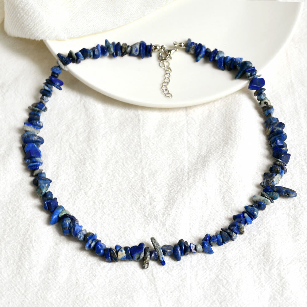 Blaue Lapislazuli-Halskette mit unregelmäßigen Steinen auf weißem Hintergrund, Schmuck für Damen.