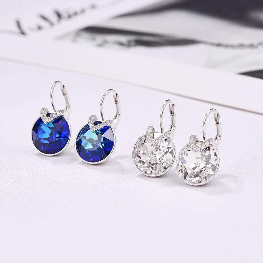 Zwei Paar Ohrringe, blau und klar, Silberfassung, funkelnde Kristalle, elegantes Design.