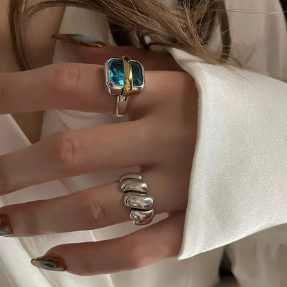 Frau mit silbernem Ring und blauem Edelstein, elegantes Schmuckdesign, Nahaufnahme.