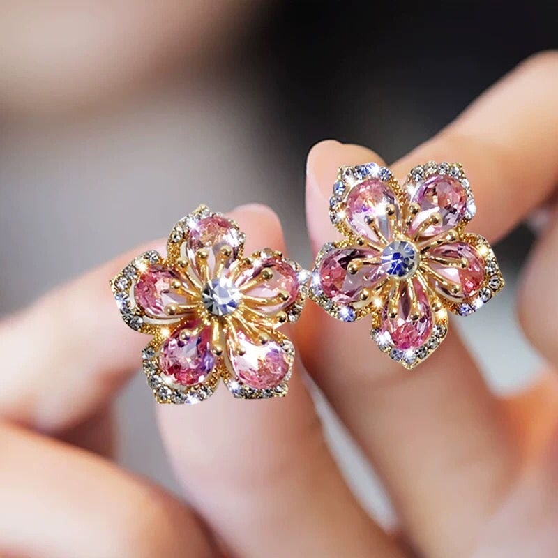 Goldene Blumenohrringe mit rosa Kristallen, funkelnd, elegant, Schmuck für Damen.