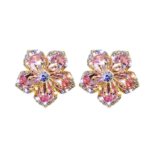 Goldene Blumenohrringe mit rosa Kristallen, funkelnd, eleganter Schmuck, Damenaccessoire.