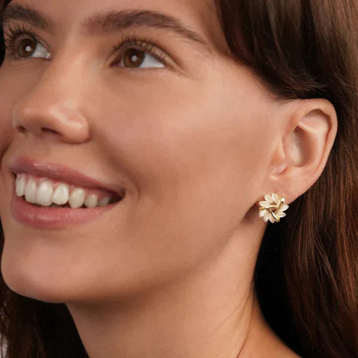 Frau mit goldenen Blumenohrringen, eleganter Schmuck, modisches Accessoire, Nahaufnahme.