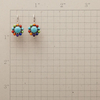 Bunte Ohrringe mit Türkis und bunten Perlen auf kariertem Hintergrund, handgefertigter Schmuck.