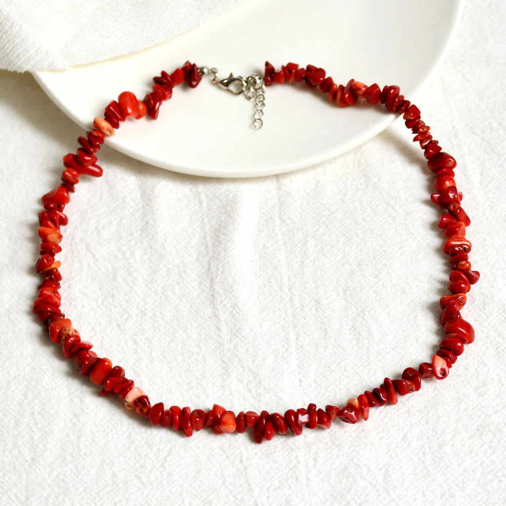 Rote Korallenkette auf weißem Hintergrund, handgefertigter Schmuck, elegantes Design.