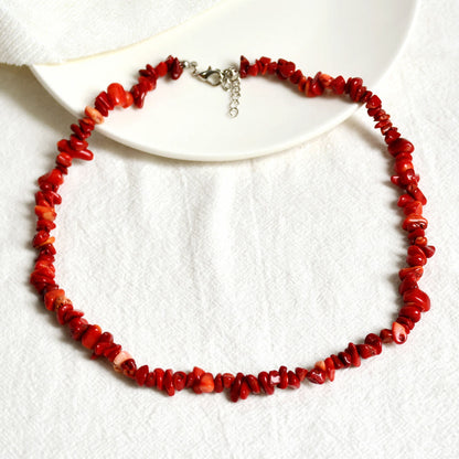 Rote Korallenkette auf weißem Hintergrund, handgefertigter Schmuck, elegantes Design.