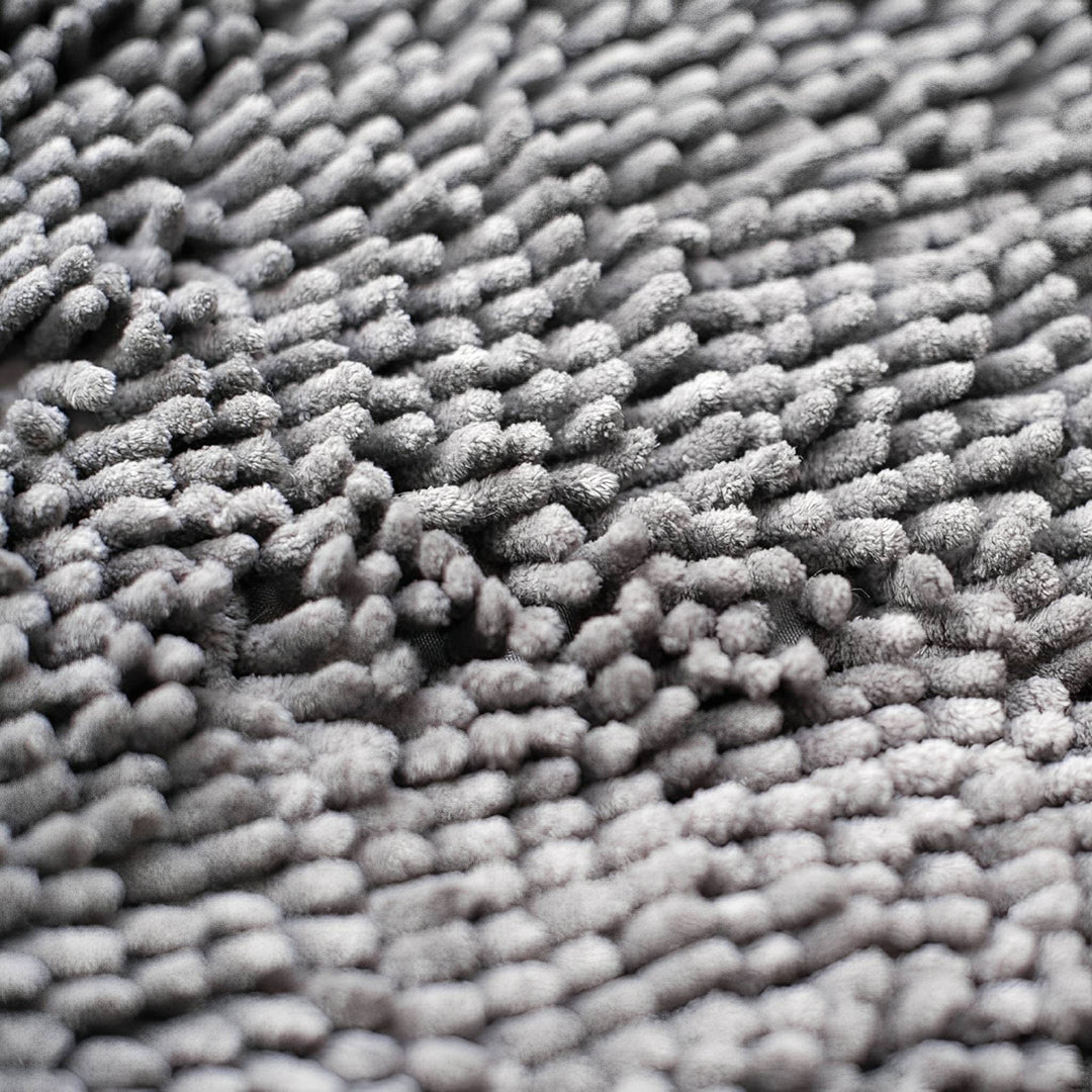 Ekstremt nærbillede af de bløde, tætte grå chenille-fibre, der giver måtten dens fnuggede struktur. 7