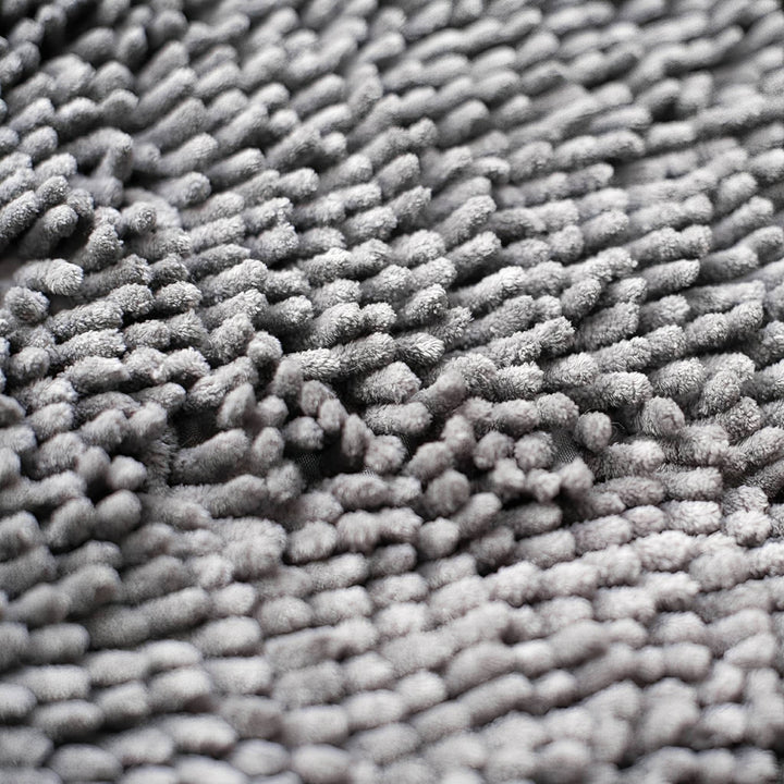 Ekstremt nærbillede af de bløde, tætte grå chenille-fibre, der giver måtten dens fnuggede struktur. 7