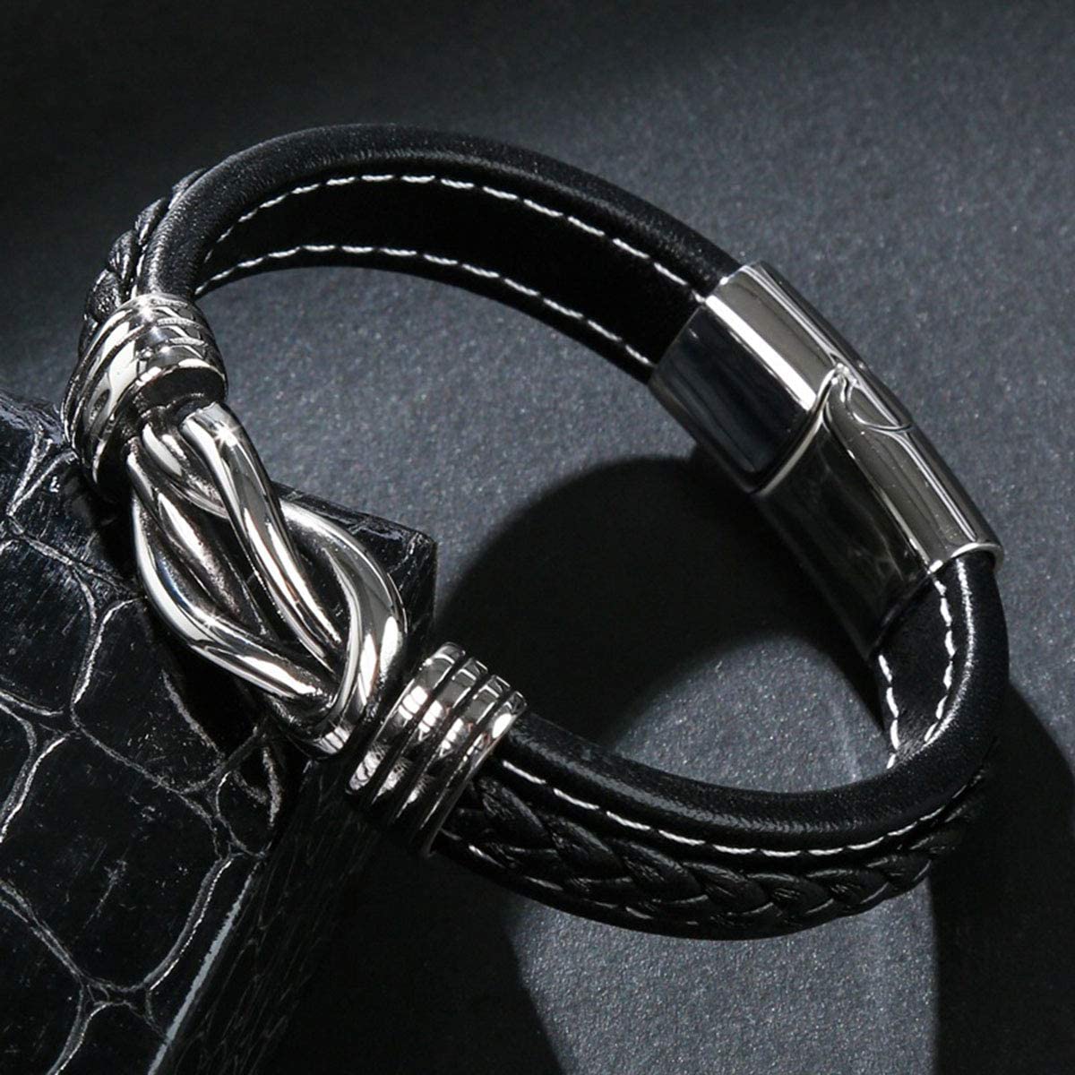 Schwarzes Lederarmband mit silbernem Verschluss, geflochtenem Design, Herrenmode-Accessoire.