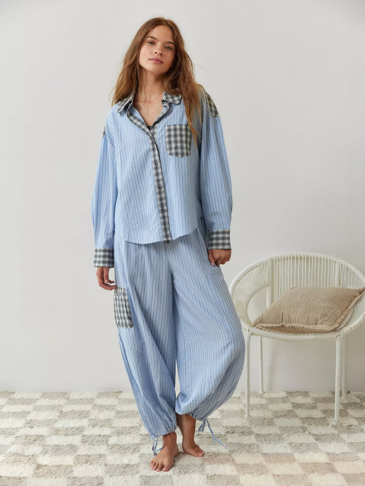 Helfigur af model barfodet i blåt stribet pyjamassæt med vide bukser med snøre om anklerne og ternet lomme på låret. 7
