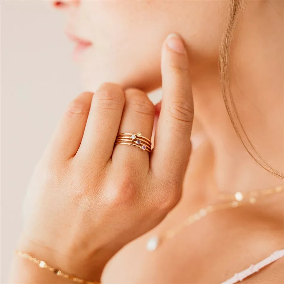 Frau mit goldenen Ringen und Halskette, Nahaufnahme, eleganter Schmuck, minimalistisch.